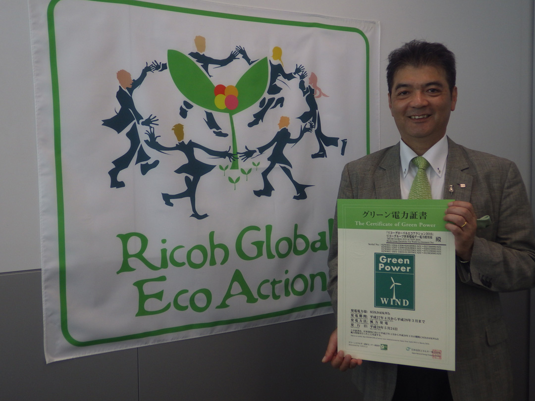 image: General Manager Kato of the Sustainability Management Division holding the Renewable Energy Certificate